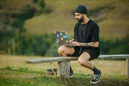 Smiling Man Sitting on Bench with Laptop Stickers