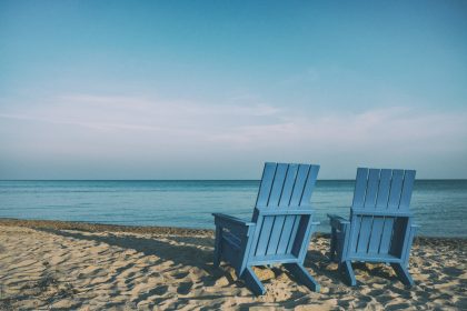 two blue beach chairs near body of water