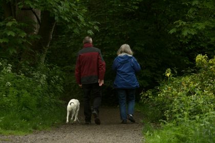 man in red jacket standing beside woman in blue jacket