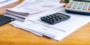 Business items on a desk, focusing on financial costs.