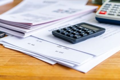 Business items on a desk, focusing on financial costs.