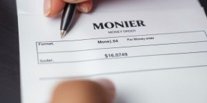 Close-up of a person filling out a money order.