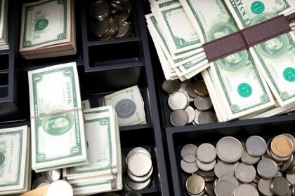 Organized cash drawer with bills and coins.