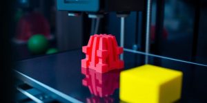 3D printer creating colorful objects on its print bed.