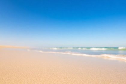 Florida beach with golden sand and clear blue sky.